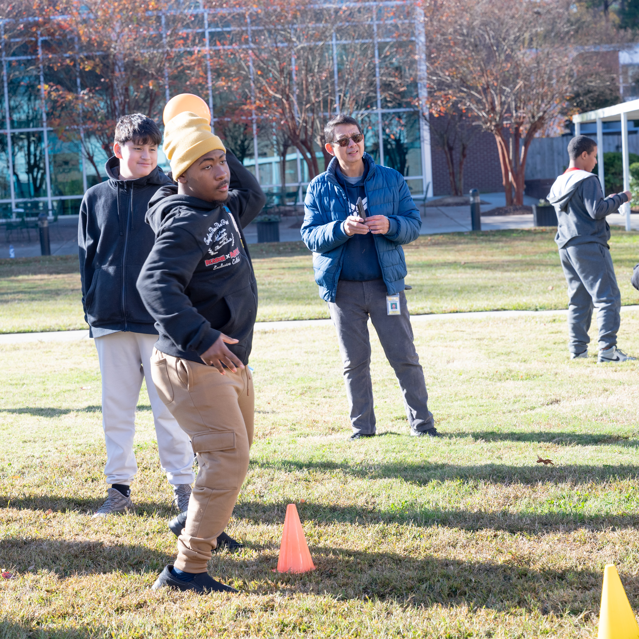 Fall Fest: Student with arm cocked to trow ball at bucket pyramid