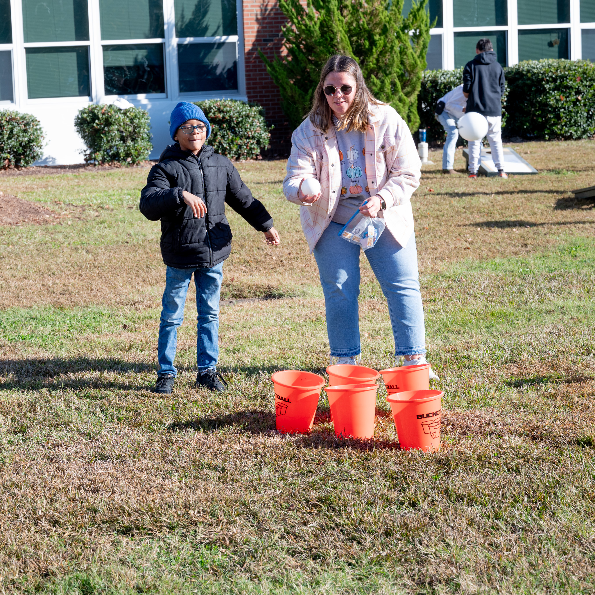 Fall Fest: Student preparing to throw a ball in to some buckets