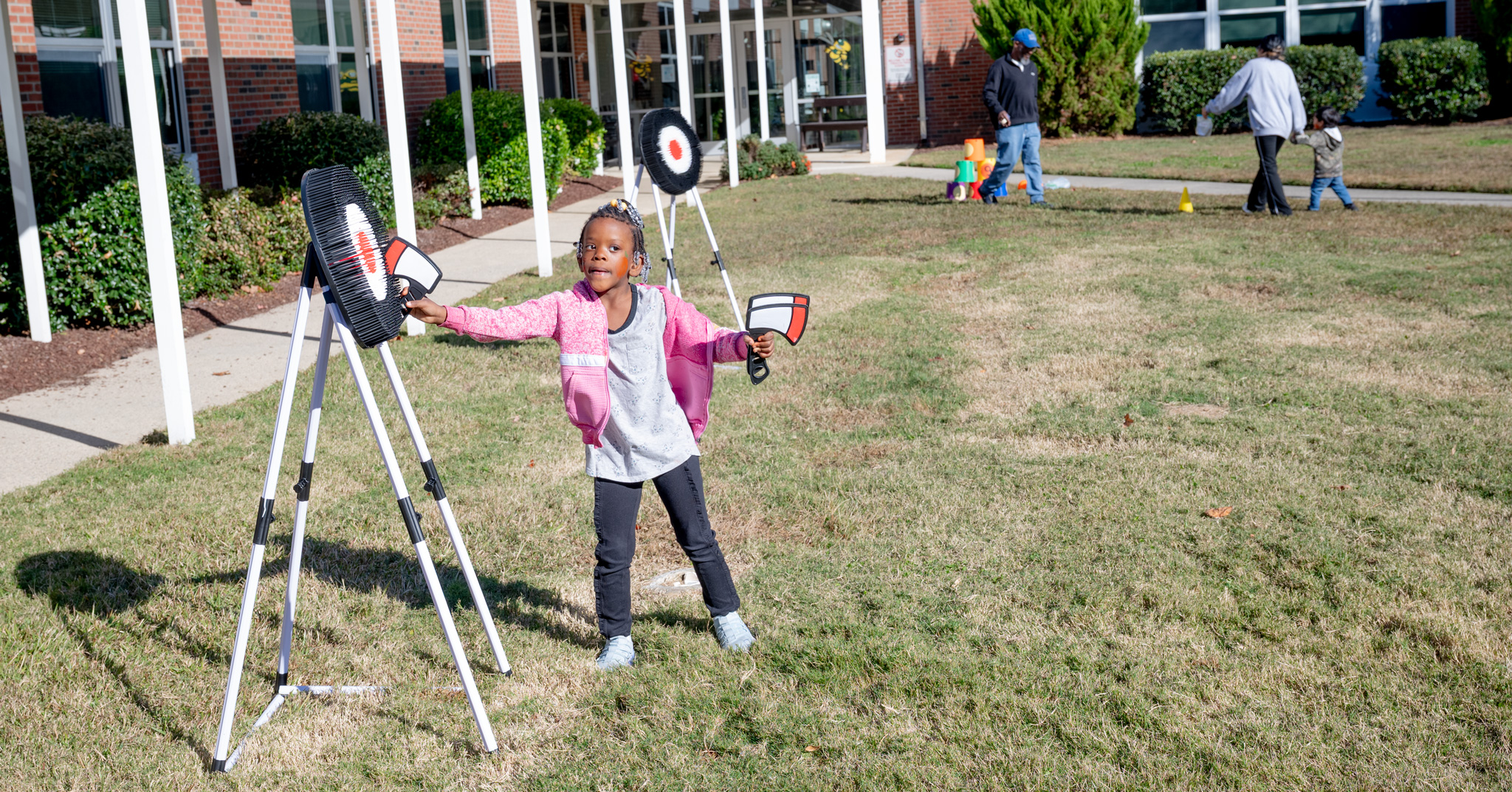 Fall Fest: Elementary student gathers plastic axes from a target