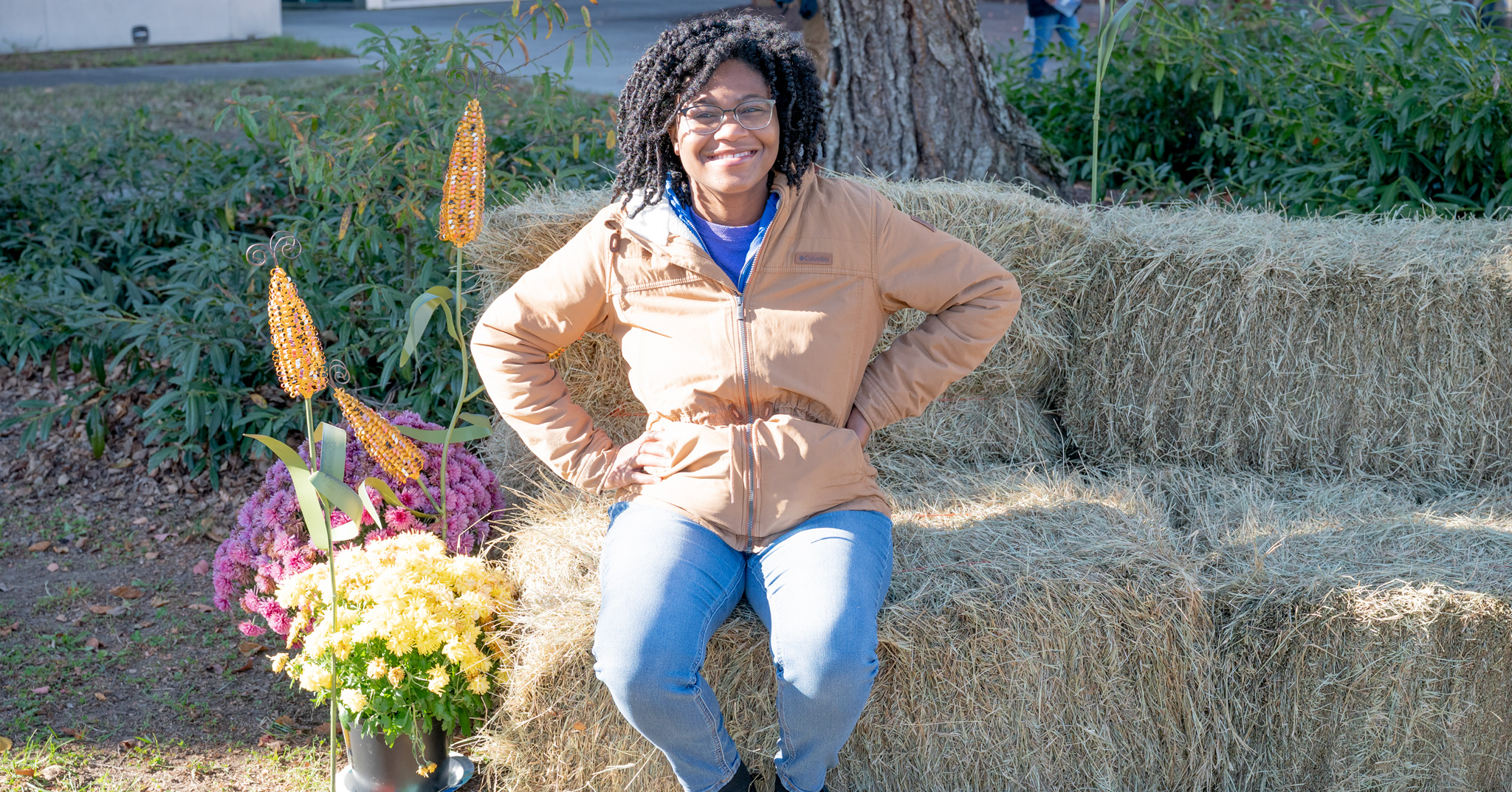 Fall Fest: Stephanie sits on a hay bale posing for a photo