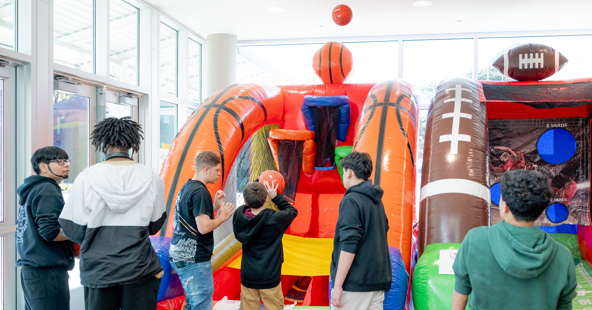Fall Fest: a group of students playing with the inflatable basketball and football games