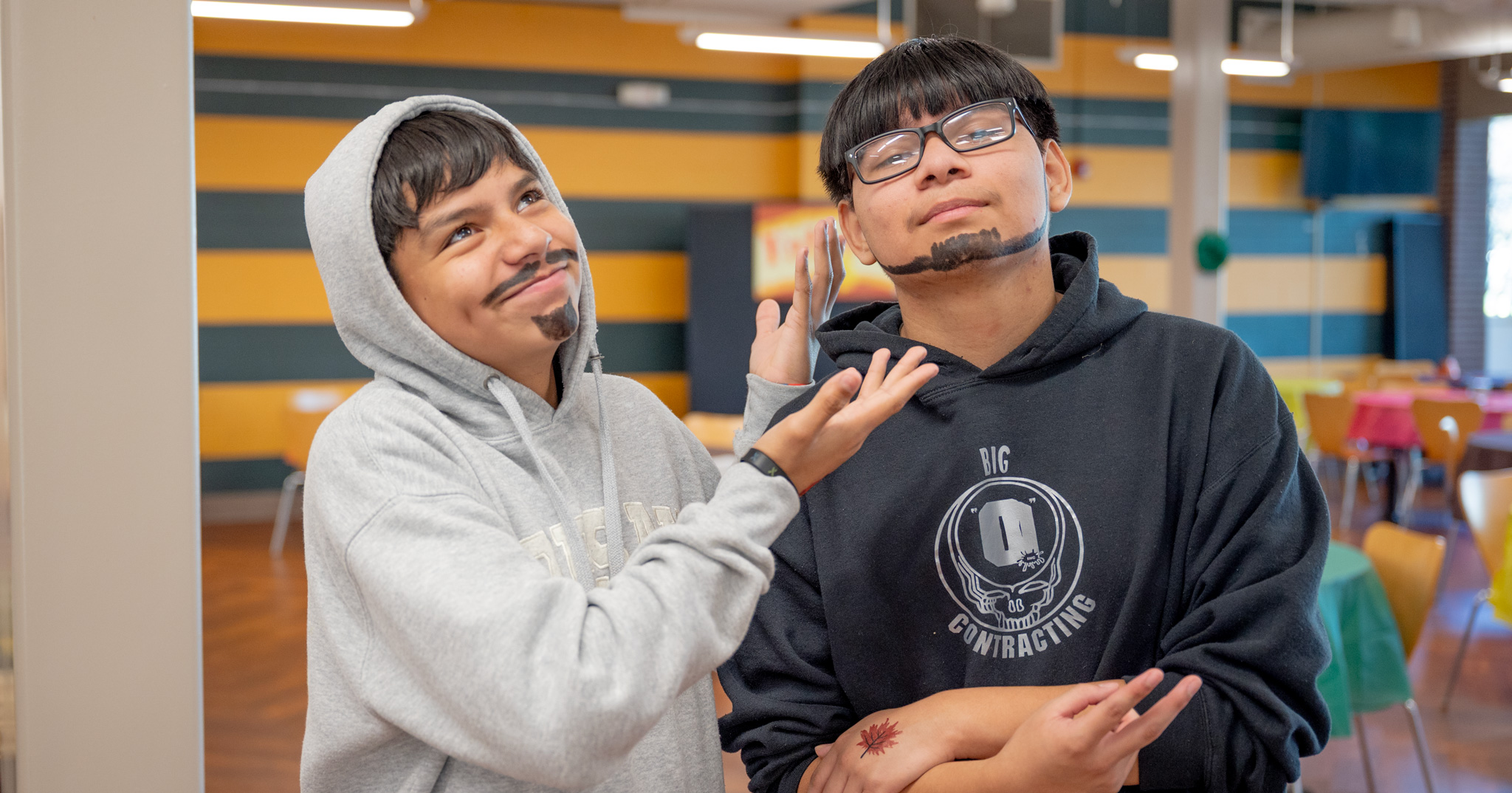 Fall Fest: Two students with face painted mustaches strike a pose for the camera
