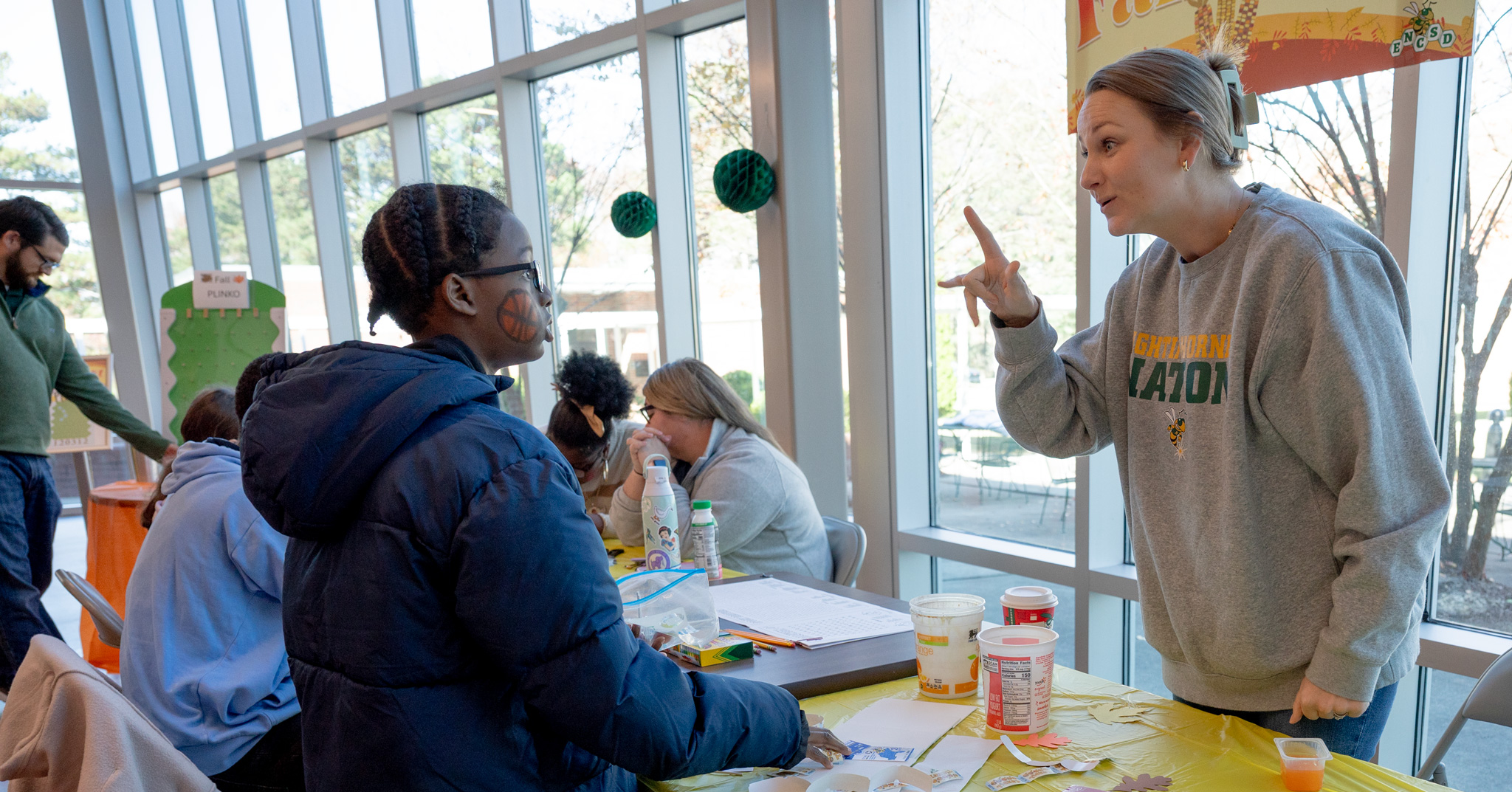 Fall Fest: Lane signs with a student about activities in the Activity Center